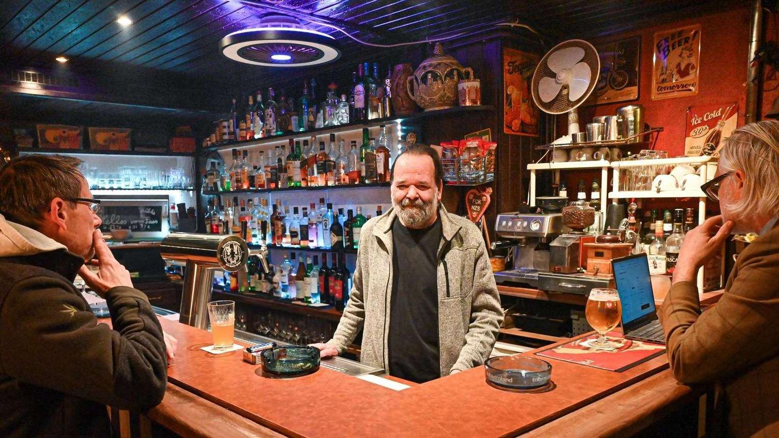 Interior de um bar com balcão e clientes